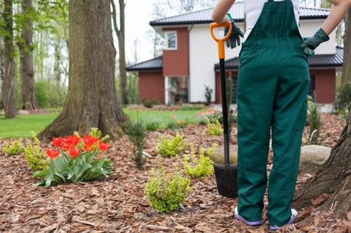 Gardener using tools in a well-maintained garden